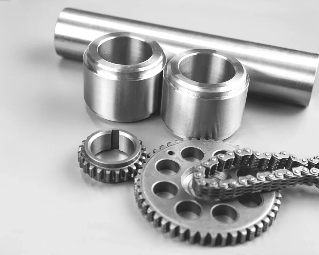 CNC precision-manufactured metal components including gears and cylindrical parts.