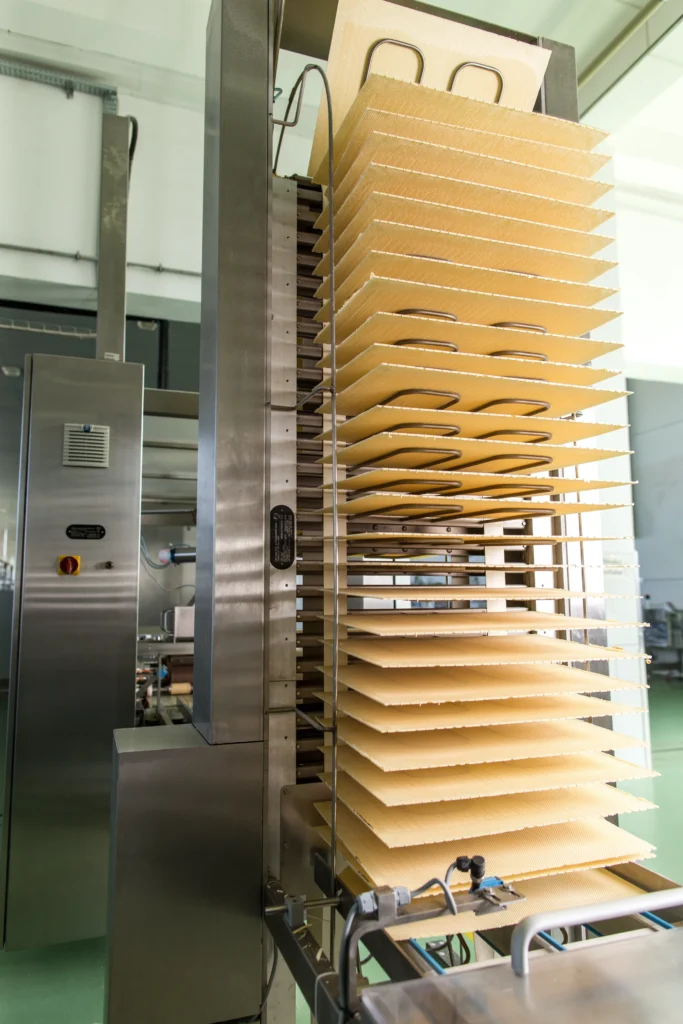 Industrial machine with stacked trays used in manufacturing processes.